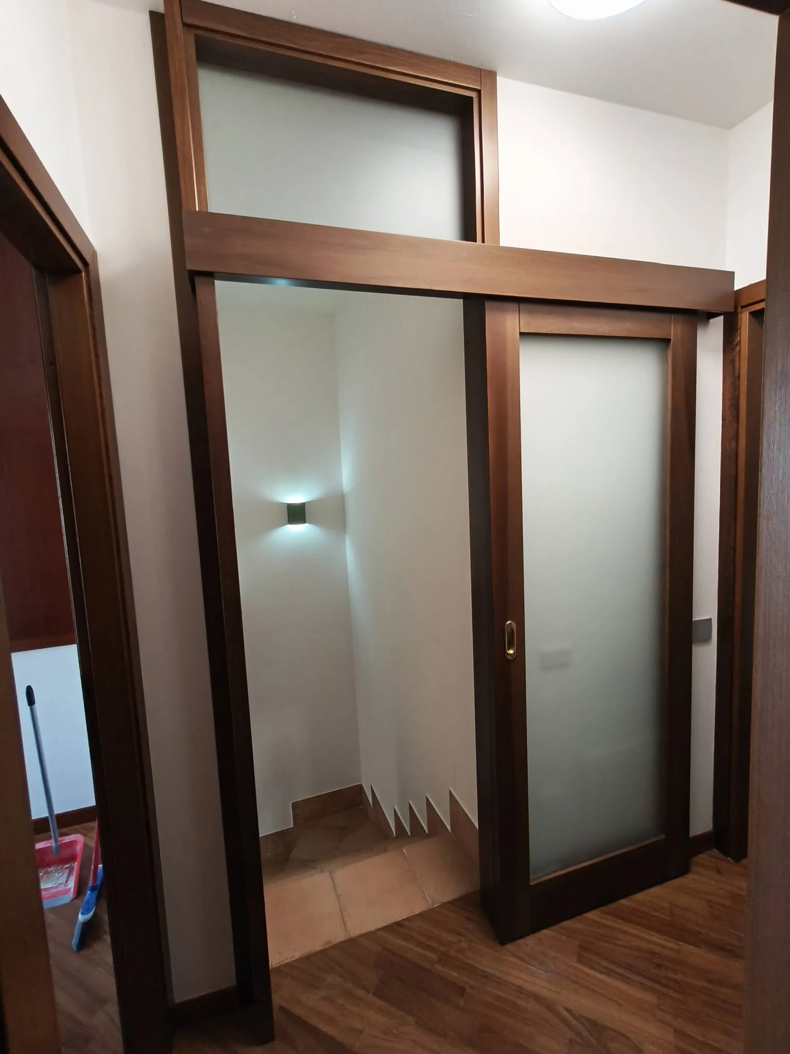 Porta scorrevole in legno con vetro satinato per chiusura vano scala. Foto 02.
