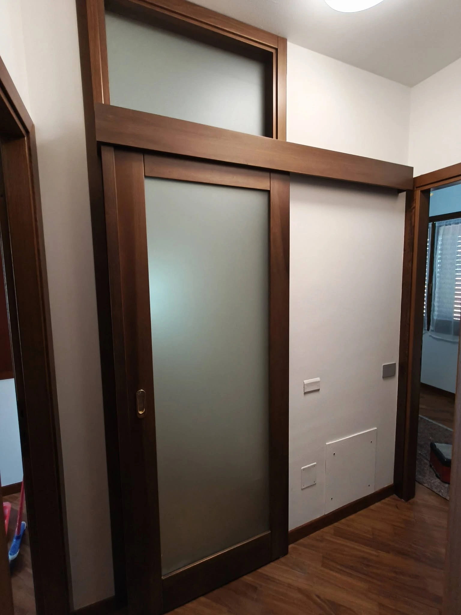 Porta scorrevole in legno con vetro satinato per chiusura vano scala. Foto 03.