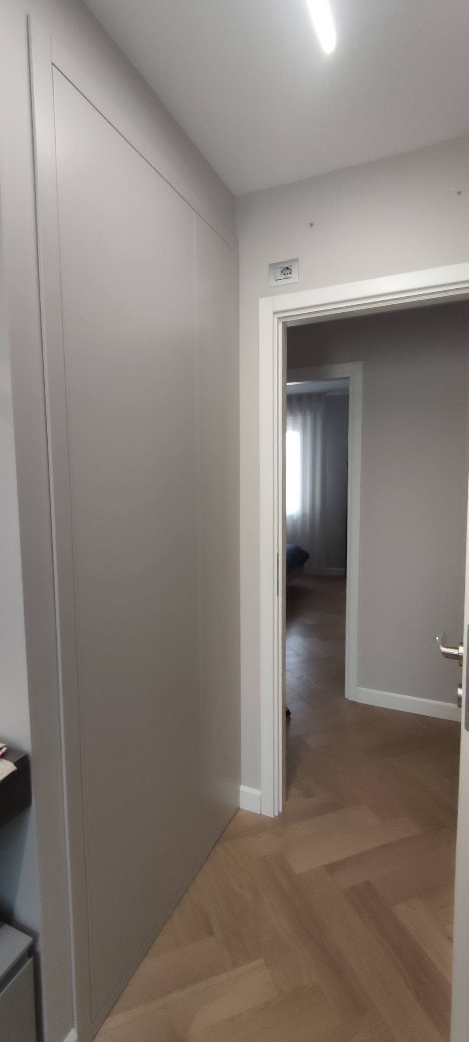 Armadio su misura a tutta altezza con ante lisce e ripiani interni realizzato per ottimizzare spazi ridotti. Foto 02.