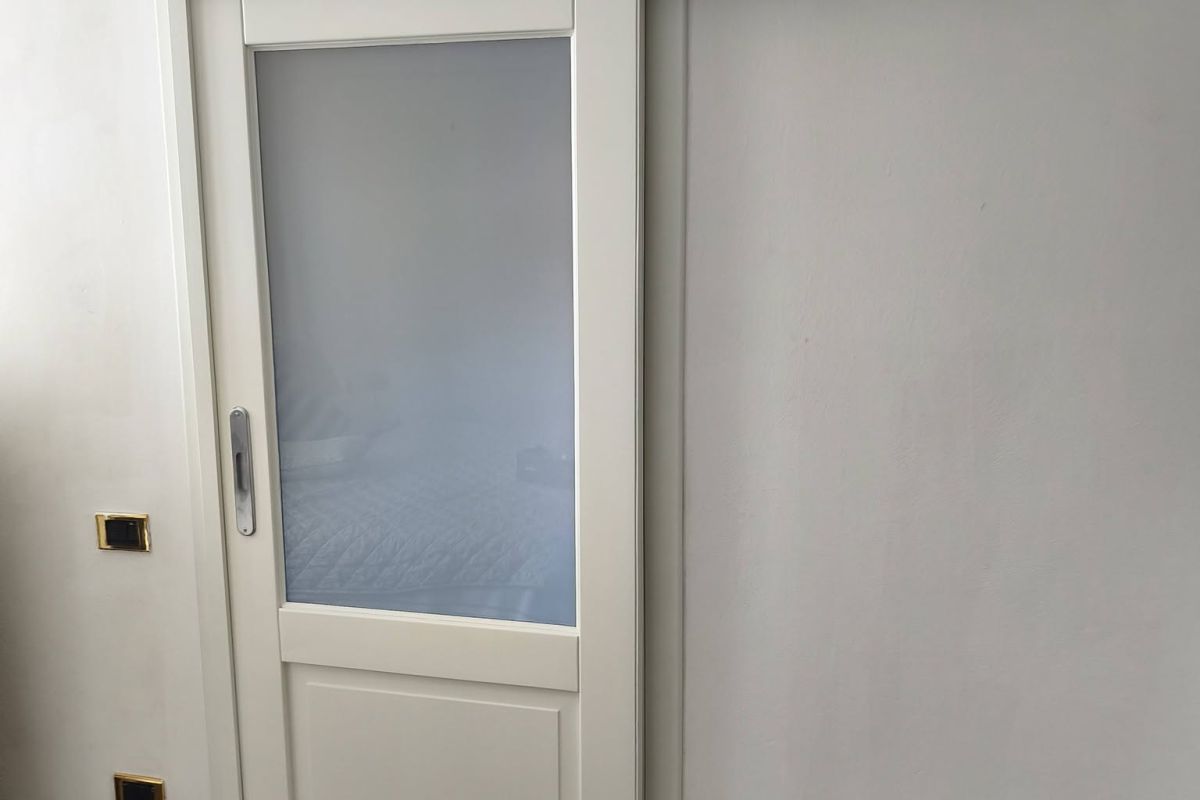 Porte in legno massello restaurate e laccate bianco avorio con vetri satinati.